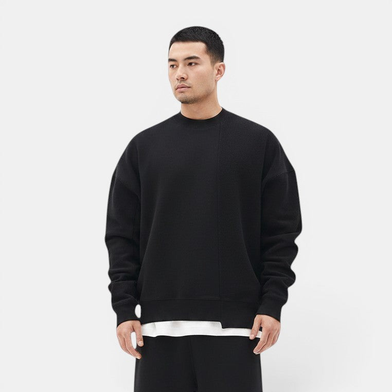 Allzom Men's black loose round-neck pullover sweater in soft knitwear with a relaxed fit and a white t-shirt peeking out from the hem.