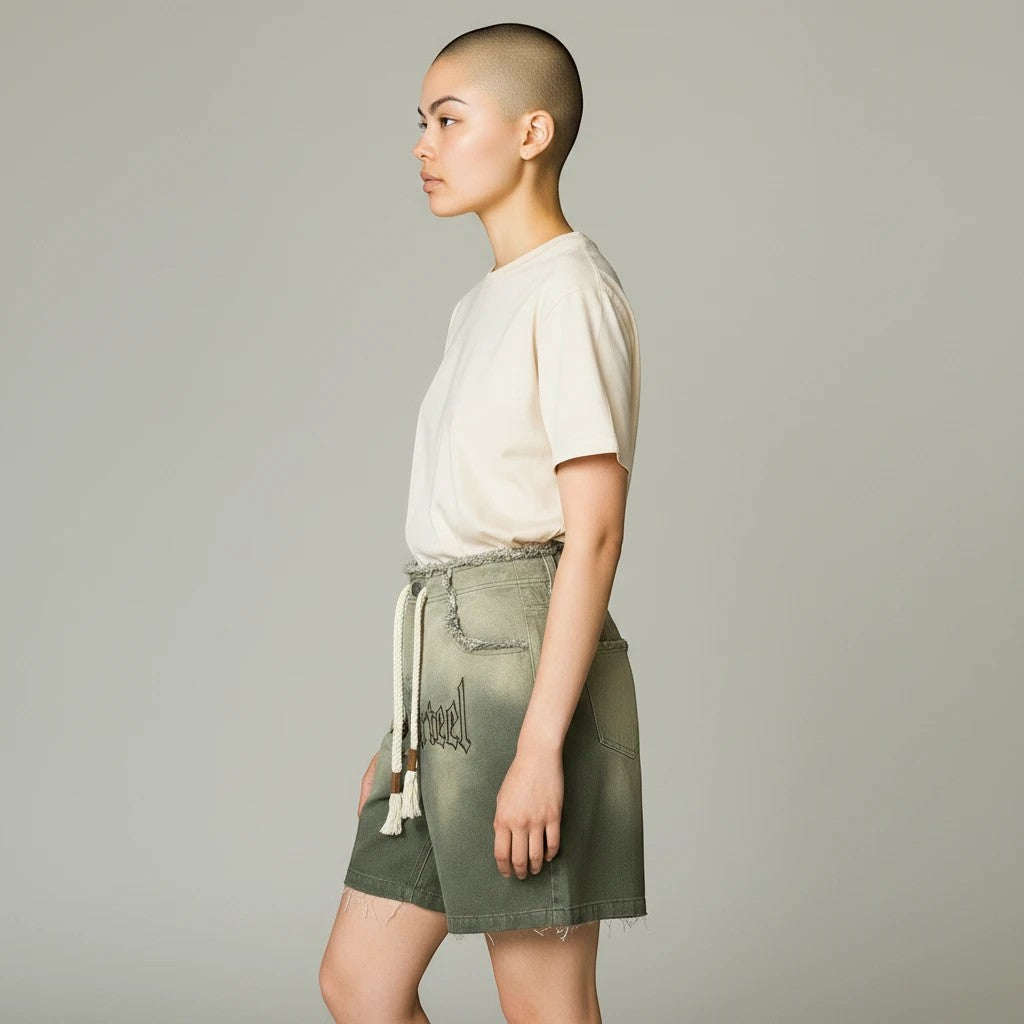 Modelo de perfil veste calções Allzom verdes de ganga lavada com cordão e bainha desfiada em estilo vintage