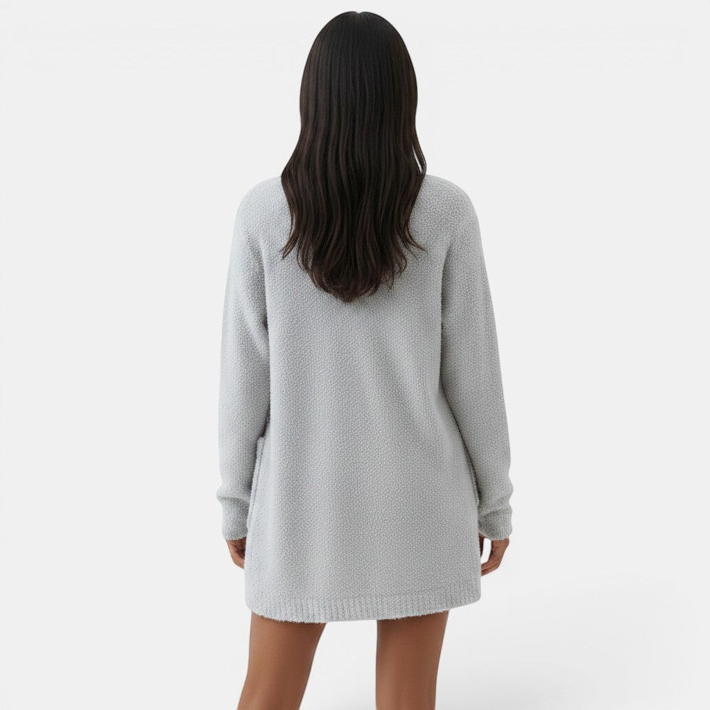 Allzom mulher de costas a usar um cardigan de malha cinza claro com bolsos laterais e bainha canelada. Roupa de salão confortável.