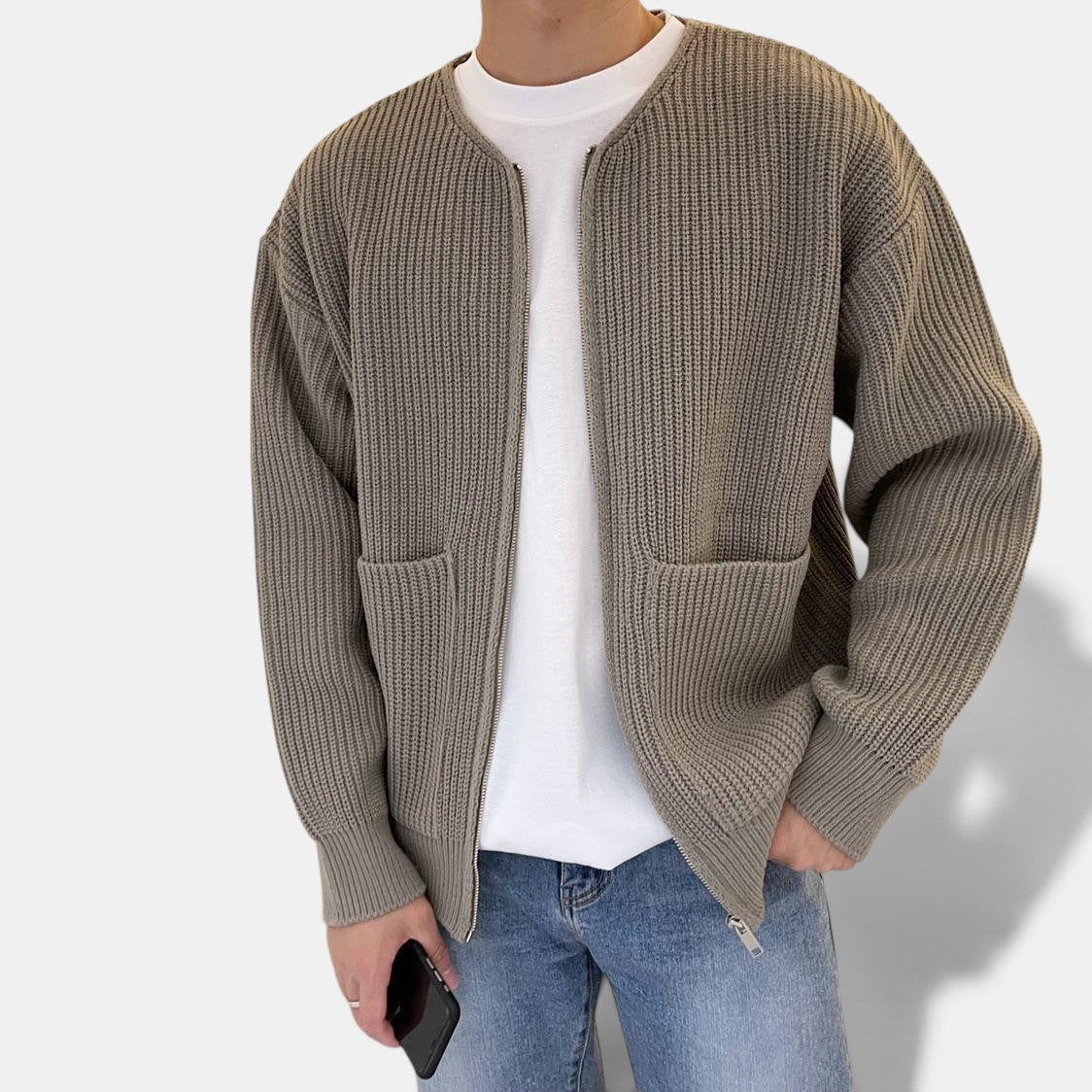Allzom cardigan de malha cinzento com fecho de correr, gola redonda e bolsos frontais, usado sobre t-shirt branca e jeans.