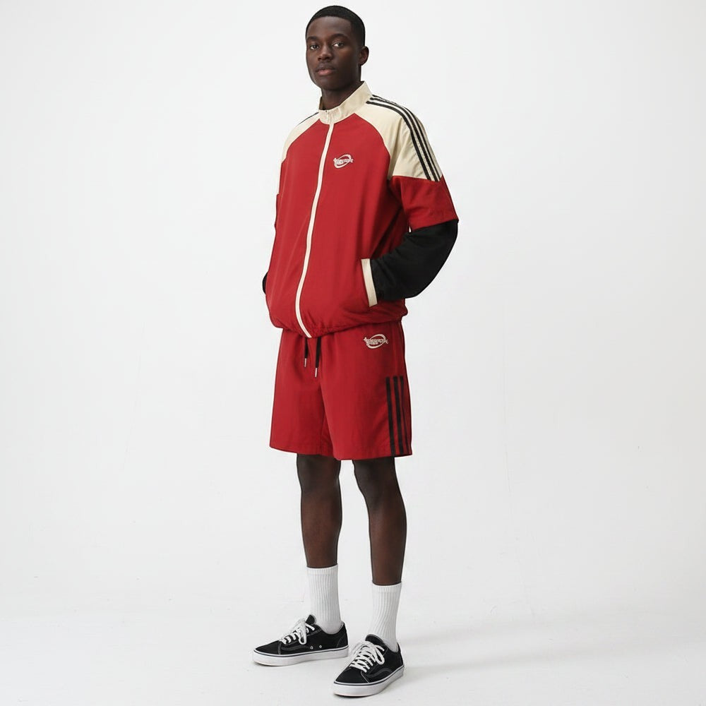 Conjunto desportivo Allzom vermelho com calções e casaco de contraste, detalhes de riscas pretas e gola alta.