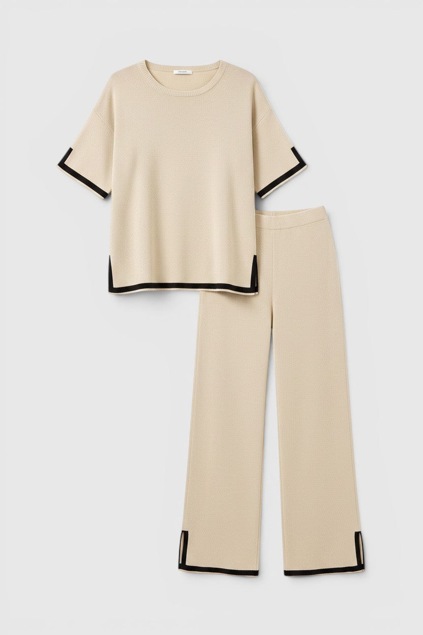 Conjunto de malha Allzom bege com detalhes em preto, top de manga curta e calças largas com fendas laterais.