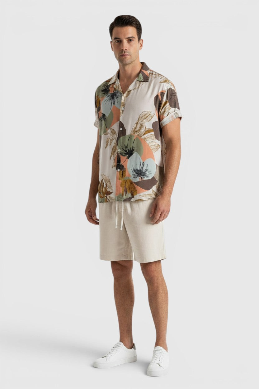 Homem veste conjunto Allzom de camisa de manga curta com padrão floral abstrato e calções bege casuais de verão