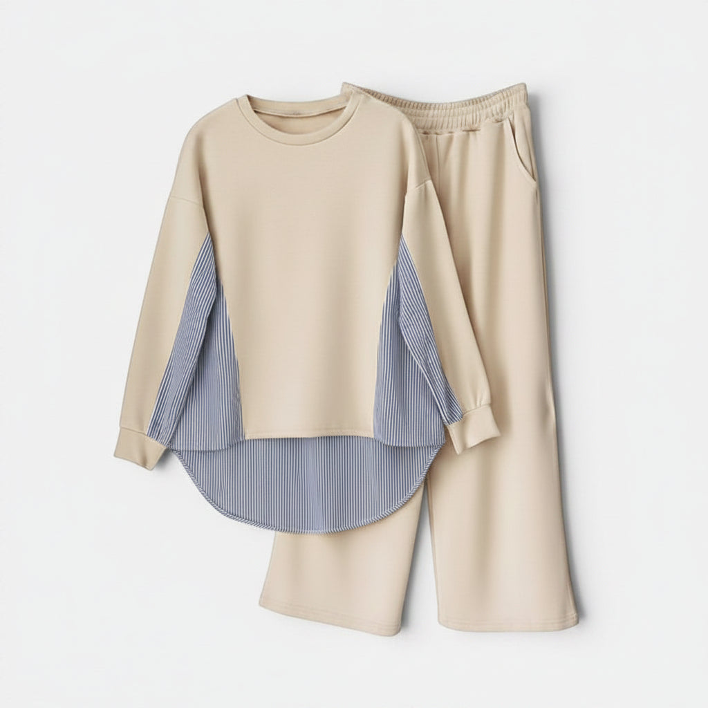 Conjunto Allzom de calças e top bege com bainha assimétrica e detalhes de riscas azuis. Top com mangas compridas e calças largas com bolsos.