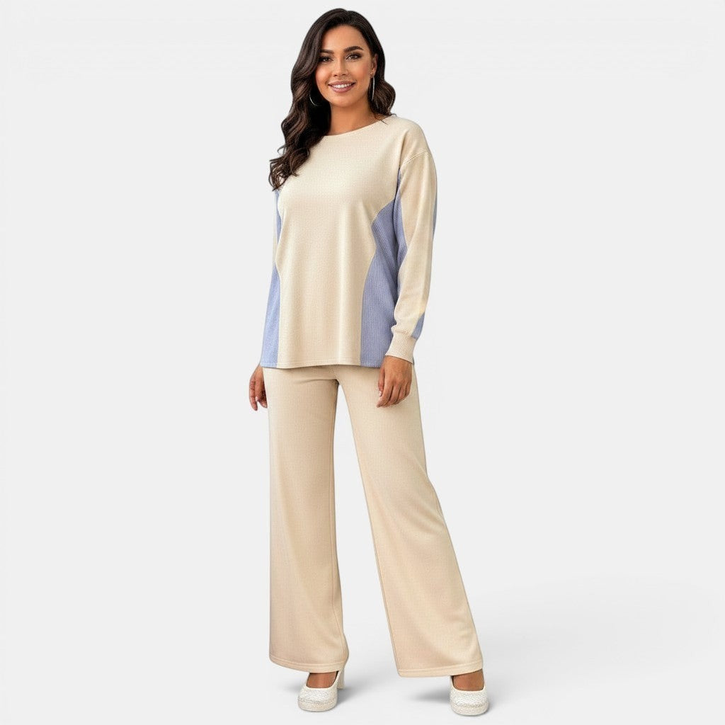 Conjunto Allzom de top bege com painéis azuis e calças bege de cintura alta com corte reto e bolsos.