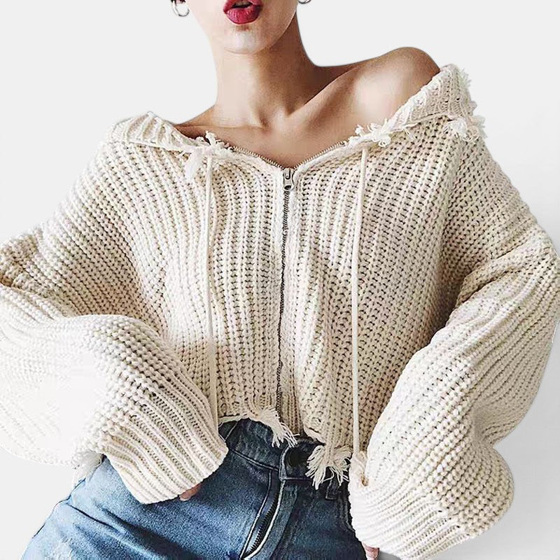Allzom cream knit hooded zipper sweater with fringe detail and wide sleeves, paired with blue jeans.