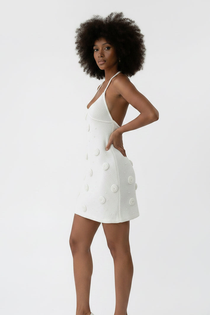 Vestido branco curto Allzom com alças finas, decote em V e costas abertas, adornado com apliques florais em relevo e pérolas.