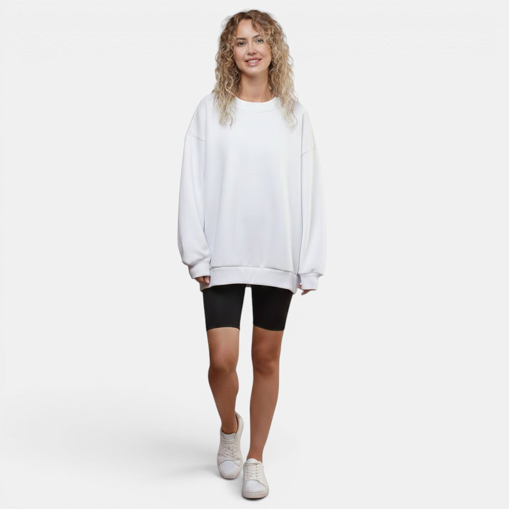 Allzom women's white crew neck loose-fit pullover sweatshirt with black biker shorts and white sneakers.